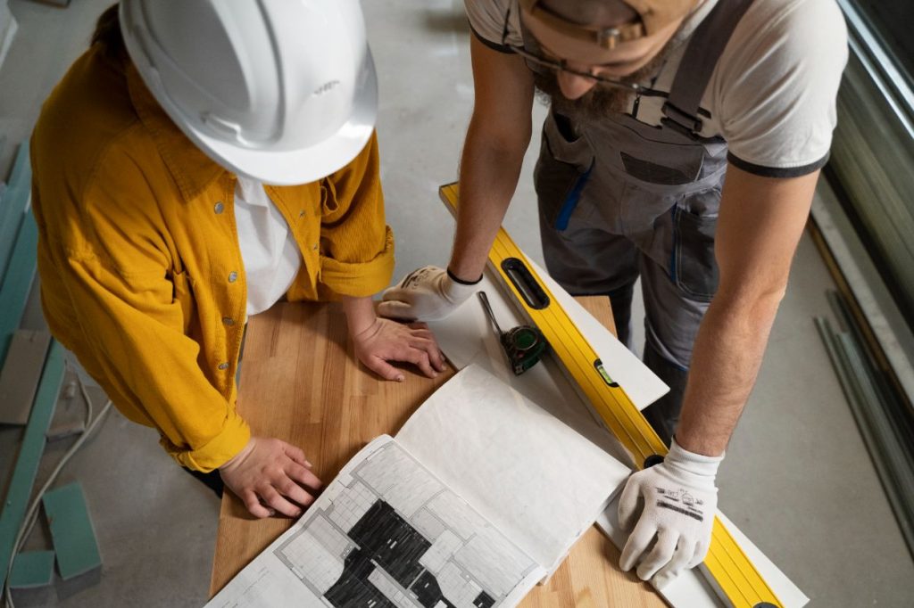 Dos personas con un plano de una obra responsable