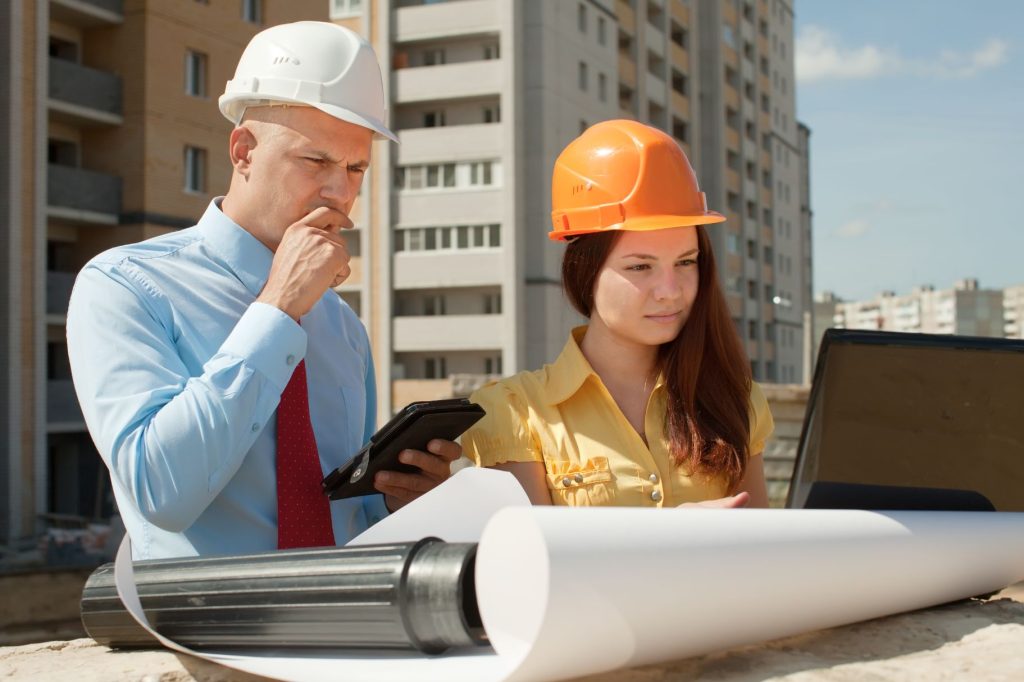 Director de obra con una mujer comprobando el certificado técnico