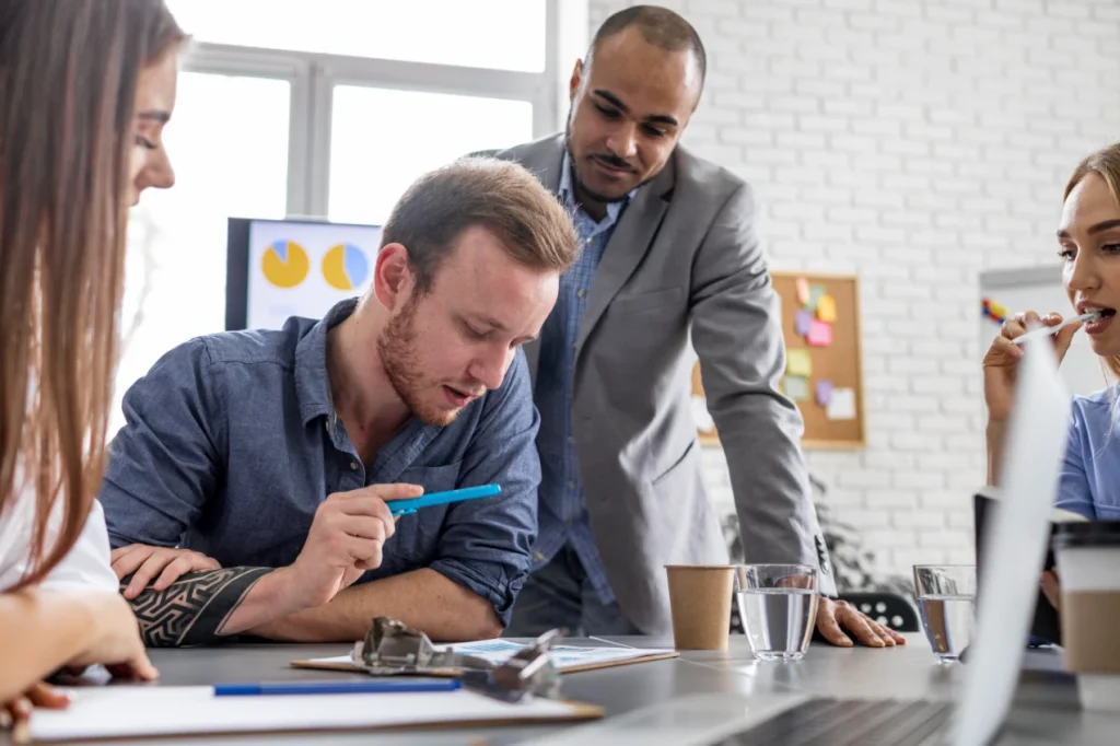 4 personas discutiendo sobre un tema en una oficina técnica